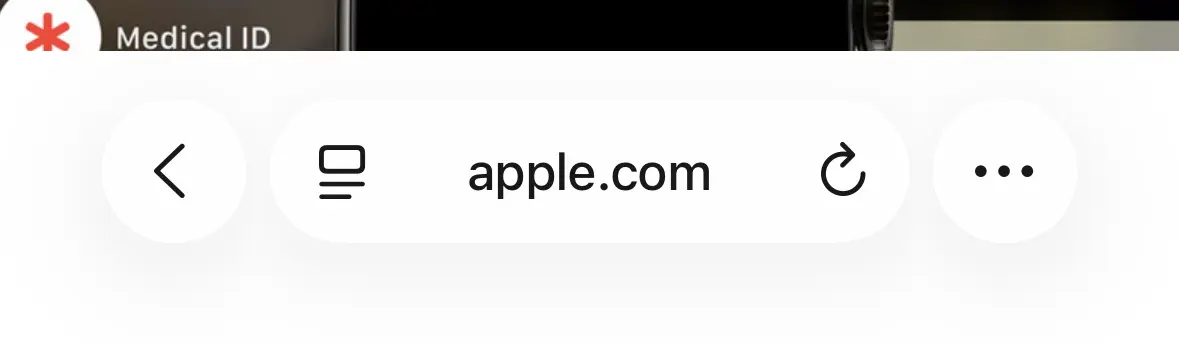 Screenshot of iOS 26 Safari showing apple.com. The glass UI has a white background colour, hiding a significant part of the website's content.